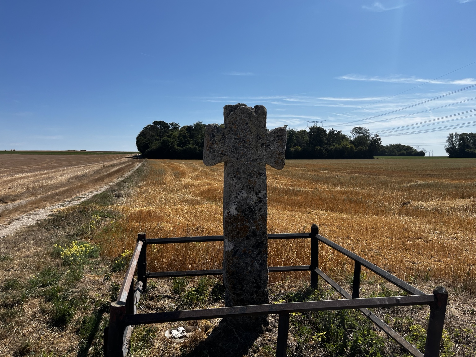 Croix en pierre au bord d’un chemin de campagne